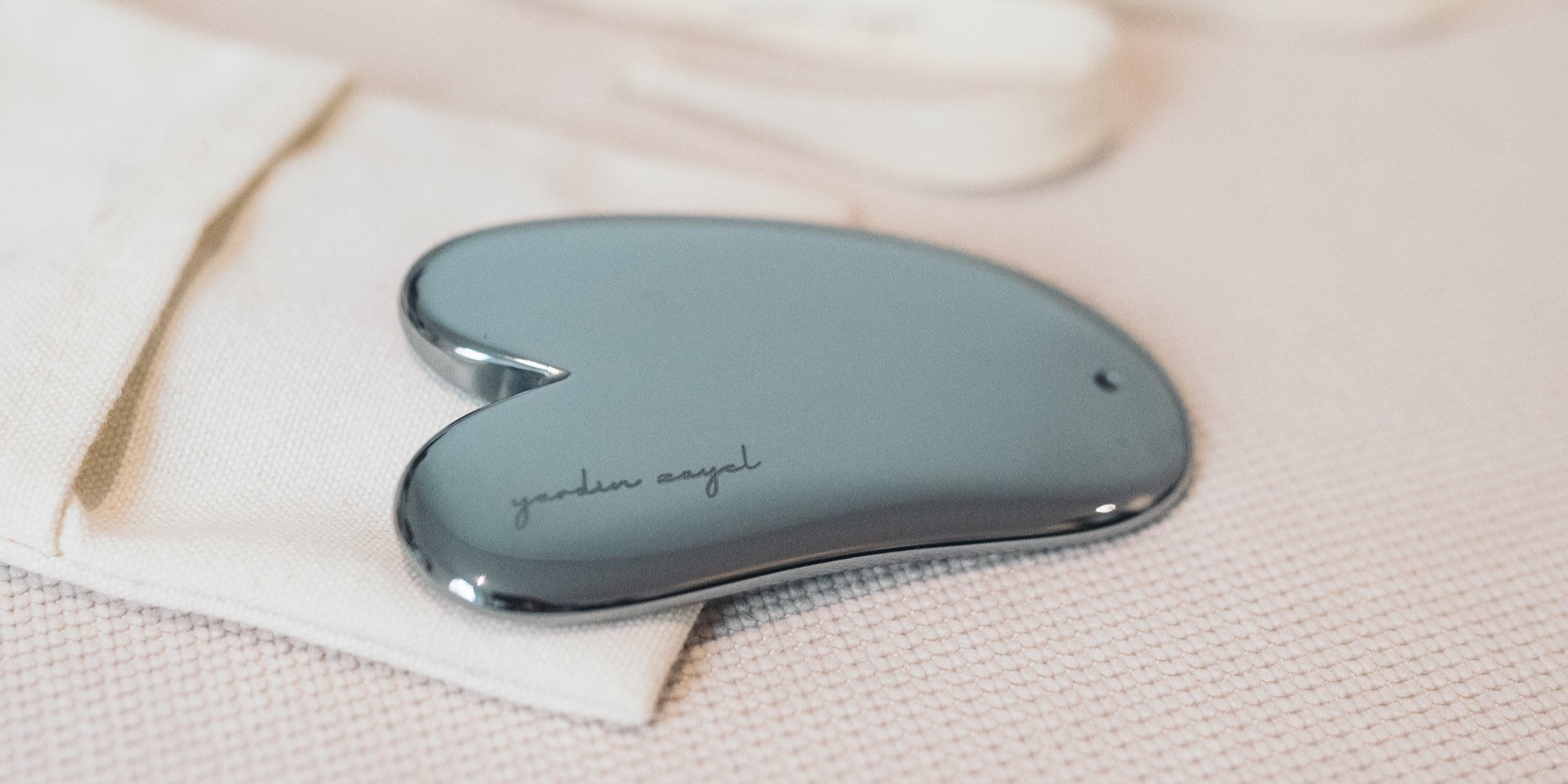 Gua Sha Teraglow aus Terahertz mit yardin zayel Gravur, dass auf der Stoffverpackung liegt