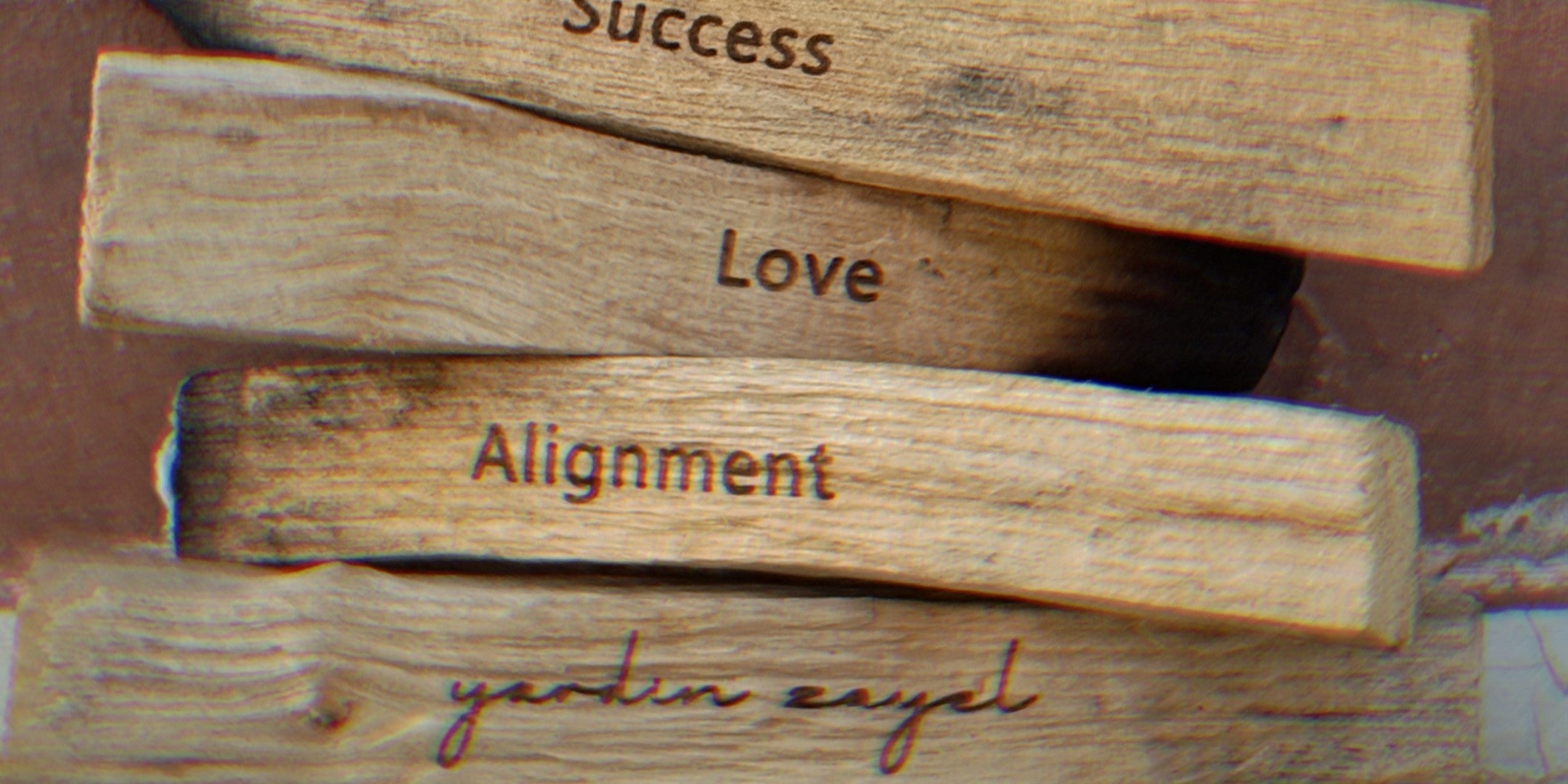 Palo Santo Sticks aufeinander gestapelt mit den Gravuren, Success, Love, Alignment und yardin zayel