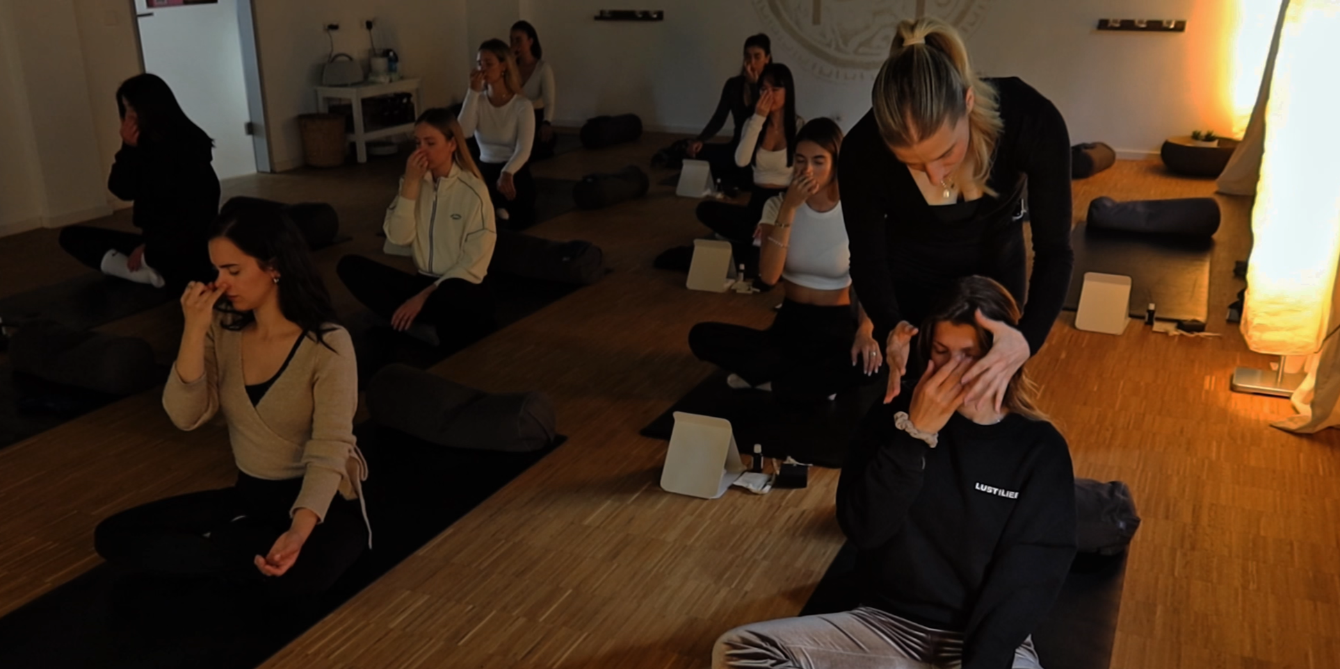 Frauen die bei einem Breathwork Workshop teilnehmen und auf Yogamatten sitzen