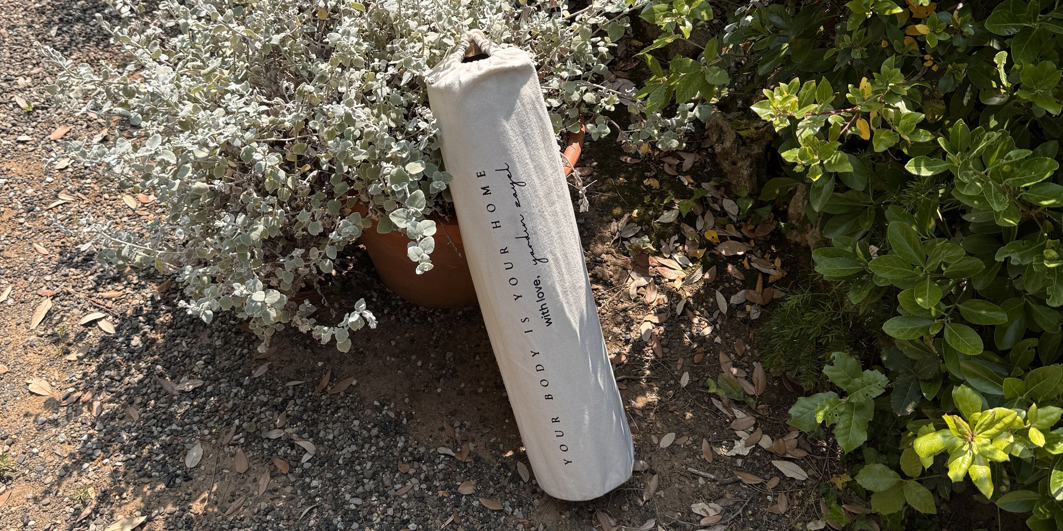 Eingepackte Yogamatte in der Natur angelehnt an einen Lavendelbusch