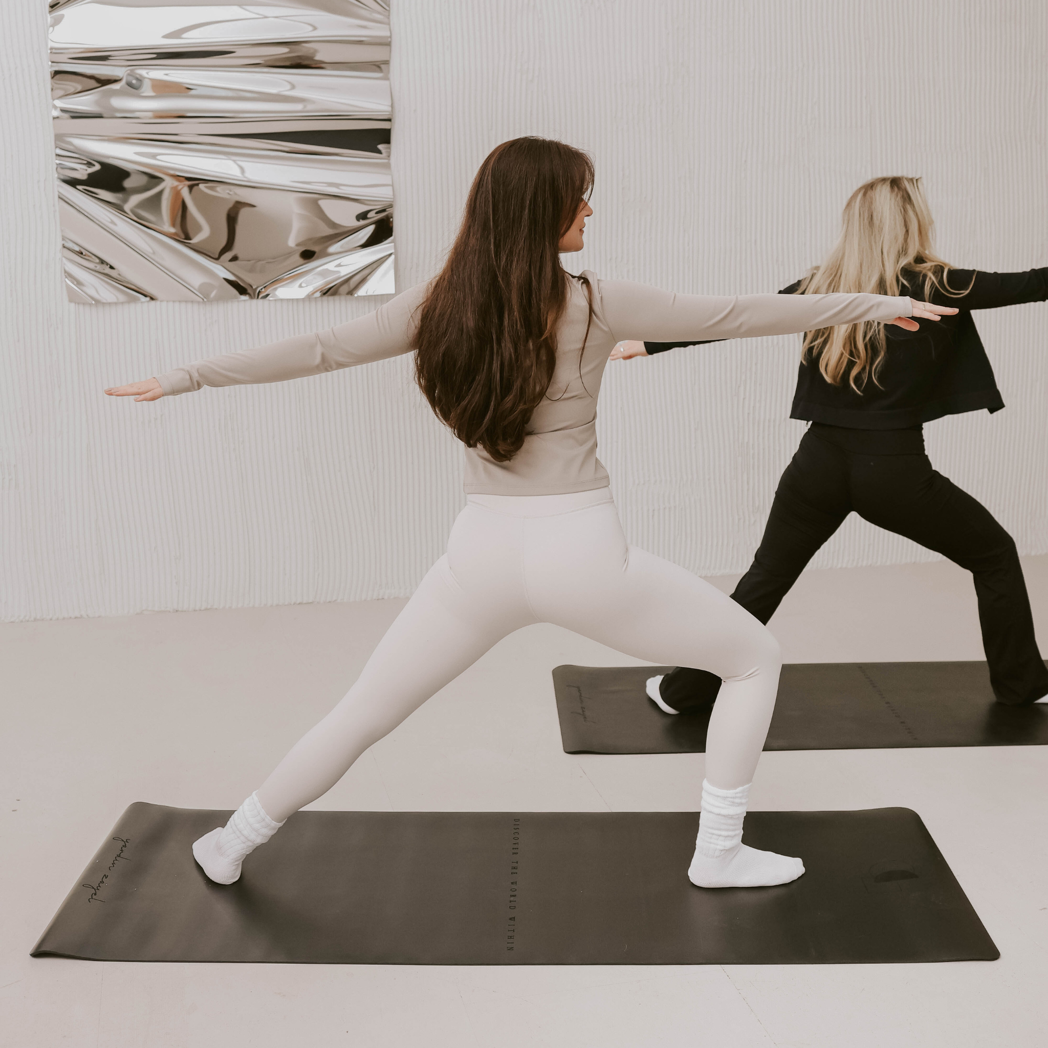 Moodbild yardin zayel DTWW Yogamatte aus Naturkautschuk in Nutzung von zwei Frauen für Kriegerposition im Yoga – rutschfest, weich und ästhetisch.