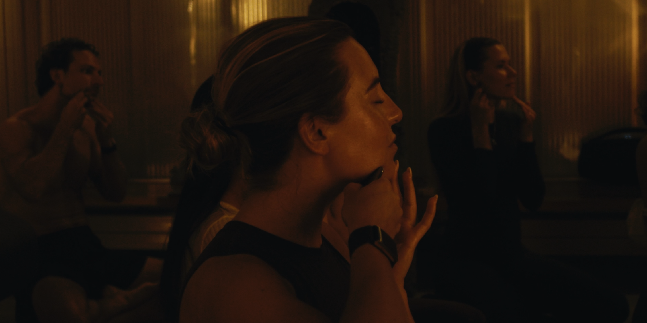 Frau in einem Raum mit gedimmten Licht, die Gua Sha anwendet