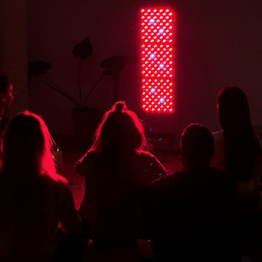 5 Frauen die vor einem Redlight Panel sitzen, dass rot leuchtet