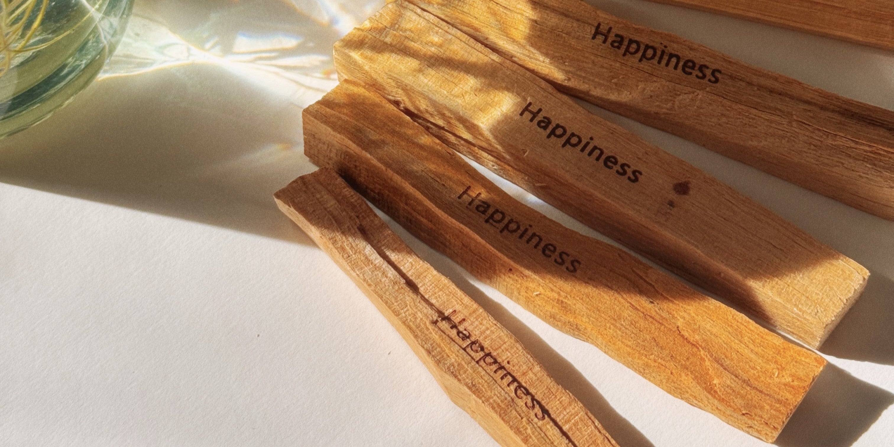 Palo Santo Sticks mit der Gravur Happiness sowie Sonnenstrahlen die drauf kommen