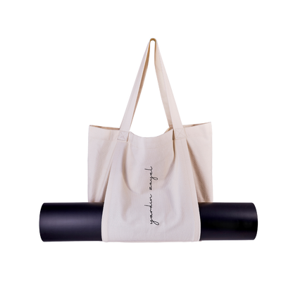 Freistellerbild, Tasche aus Canvas mit Yogamatten-Halterung in naturweiß, yardin zayel Logo-Print auf der Front. Schwarze Yogamatte in der Halterung. 