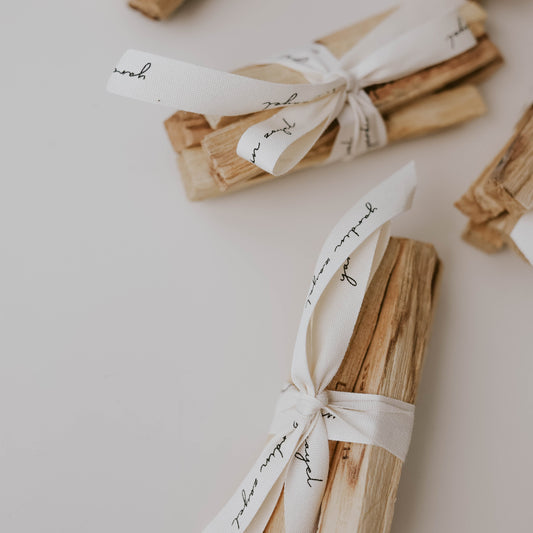 Mehrere Bundle aus Palo Santo Hölzern mit yardin zayel Logo und Mantra-Gravur. Gebunden mit Stoffband dass mit yardin zayel Logo bedruckt ist.